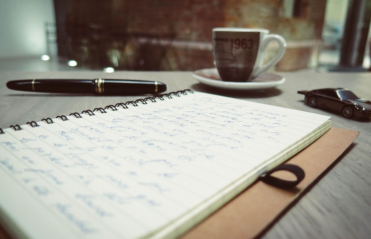 Ruhiger Arbeitsplatz mit Notizbuch und Kaffeetasse