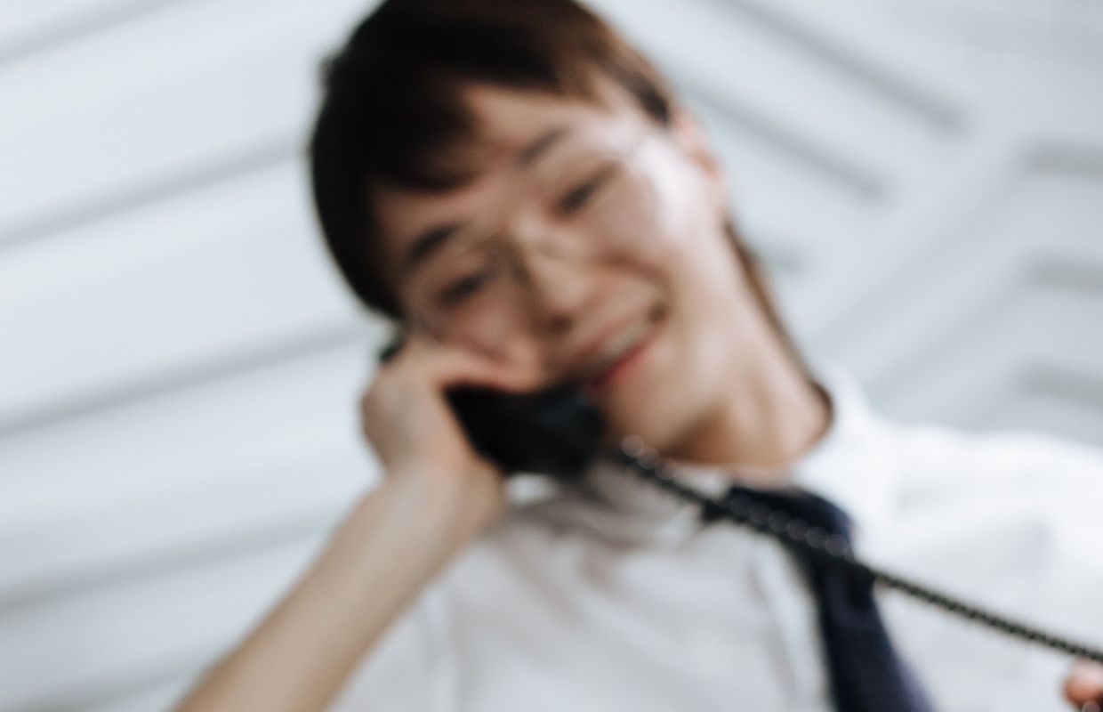 Freundliches Lächeln beim Telefonat am Hörer